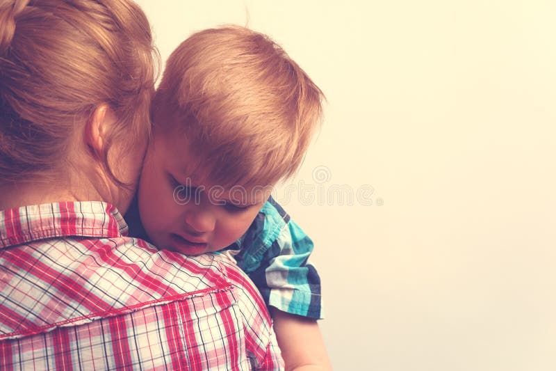 Sad unhappy child hugging his mother. Young mother comforting her little boy. Sad unhappy child hugging his mother. Family relations problems stock images