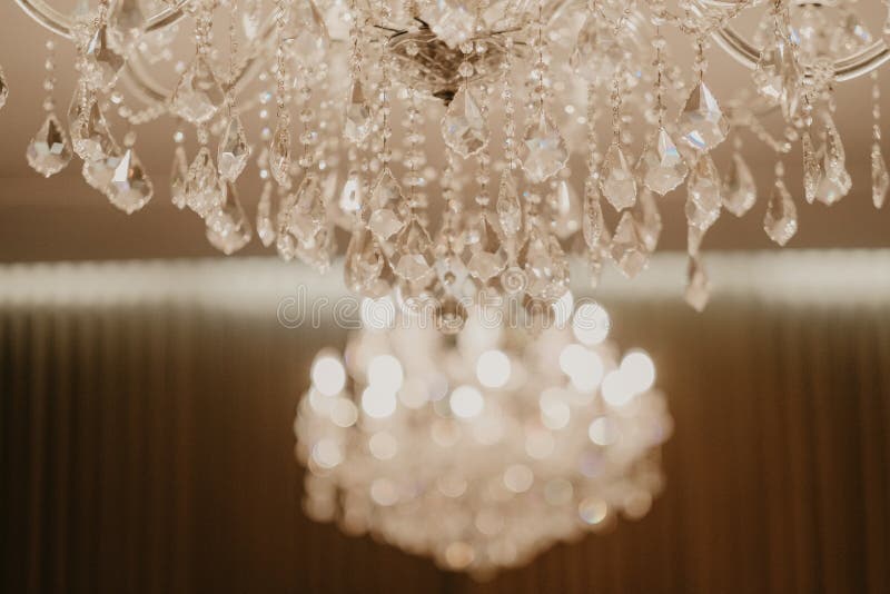 Selective focus shot of glass crystals hanging on a luxury chandelier. A selective focus shot of glass crystals hanging on a luxury chandelier stock photo