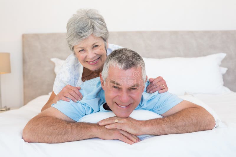 Senior woman lying on husband in bedroom stock photos