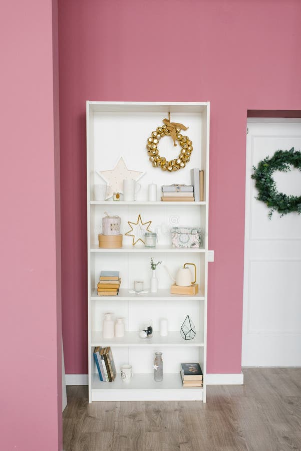 Shelf with Christmas decor in a pink colored living room and hallway stock images