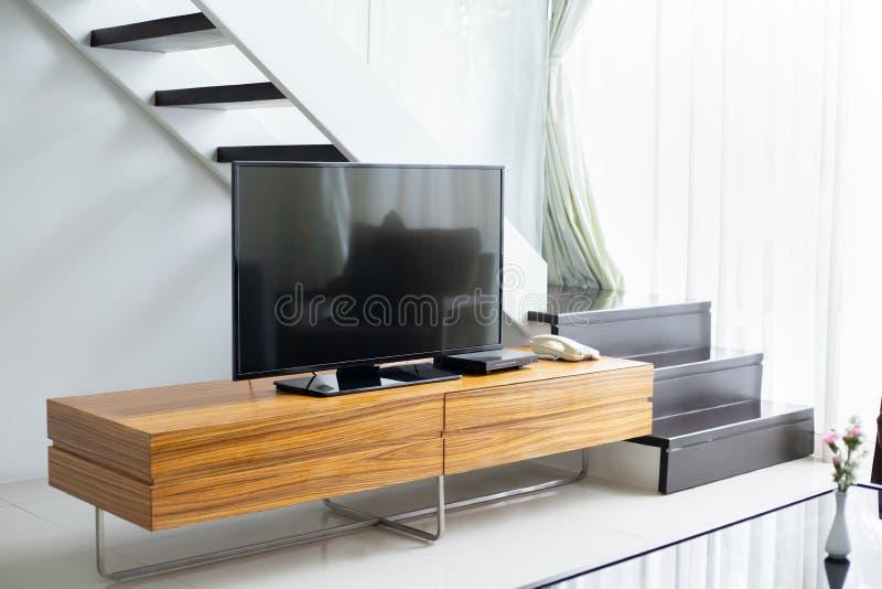 Smart TV wide screen stand on cabinet wooden in the modern living room. Concept of less is more interior design stock images