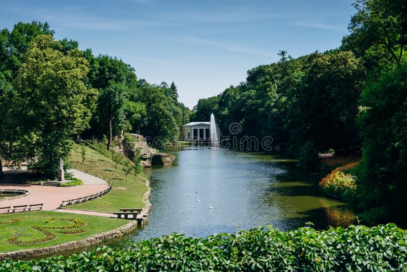 Sofia Park, Ukraine. Dendrological park in summer sunny day. Lake and fountain in a green park. Gazebo by the lake with a fountain stock image