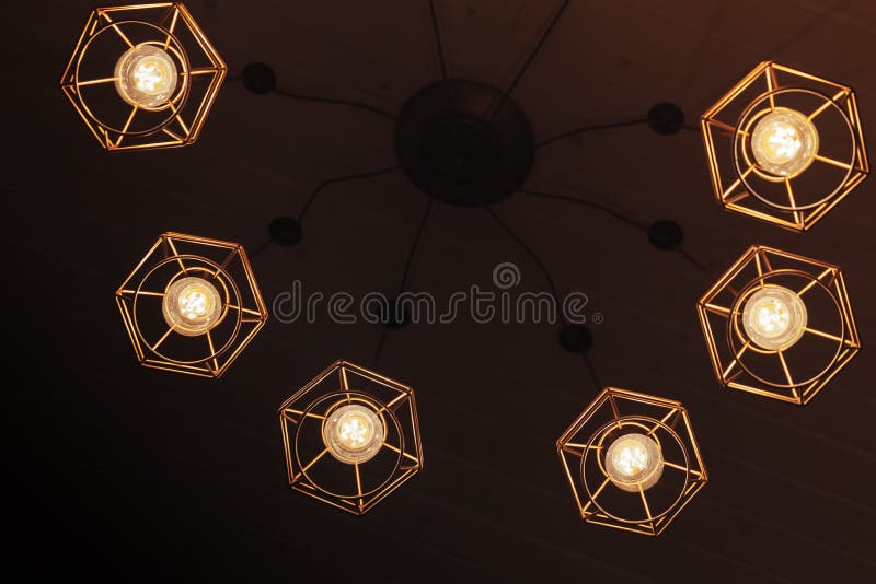Spider type chandelier with hanging bulb lamps. Spider type ceiling chandelier with hanging bulb lamps, yellow LED lighting elements royalty free stock photos