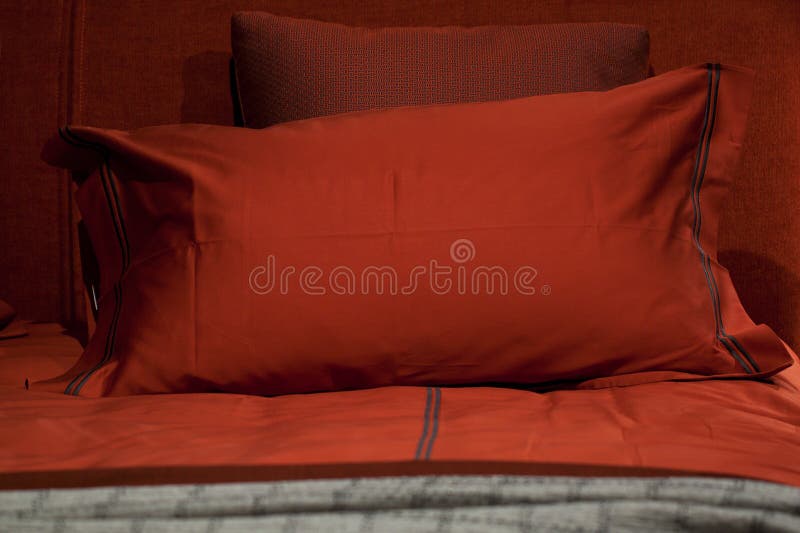 Stylish comfortable red pillows on the bed in the bedroom stock image