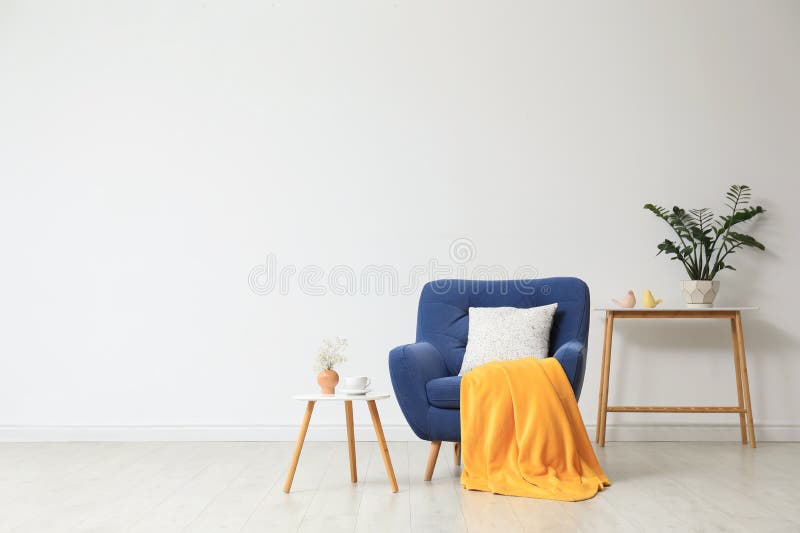 Stylish living room interior with comfortable blue armchair near white wall. Space for text stock images