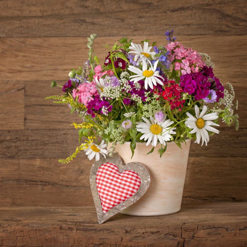 Summer flowers in vase. On wooden background royalty free stock images