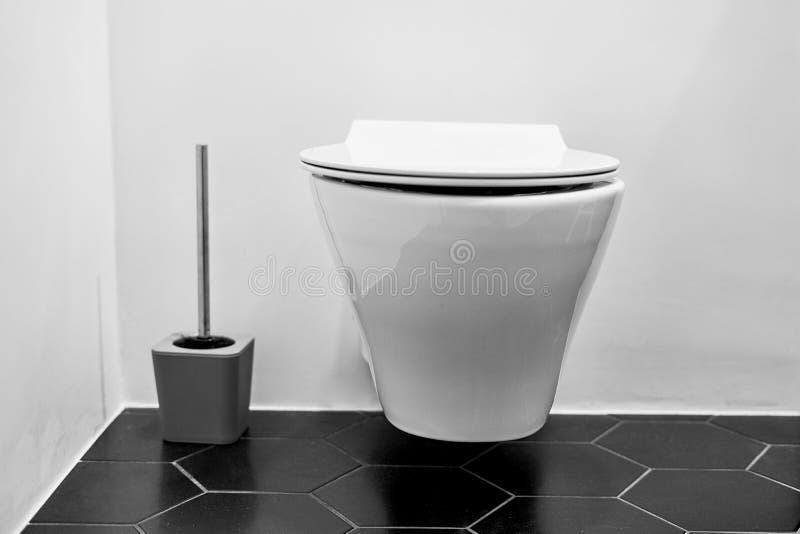 Suspended toilet in wc with black tiles on the floor stock images