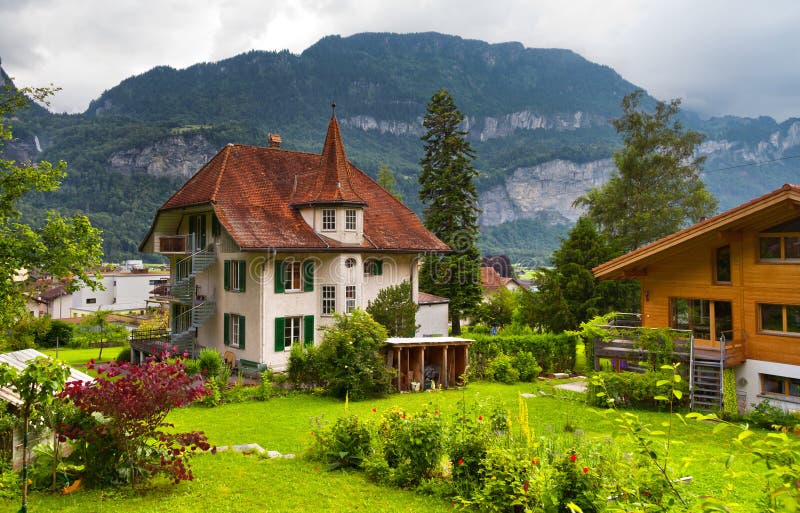 Swiss houses with a garden. The traditional, wooden, swiss houses with a garden against mountains stock photography