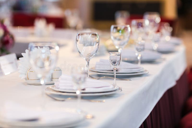 Table settings with white wine glasses and glasses of spirits. Wedding decor, restaurant layout. stock images