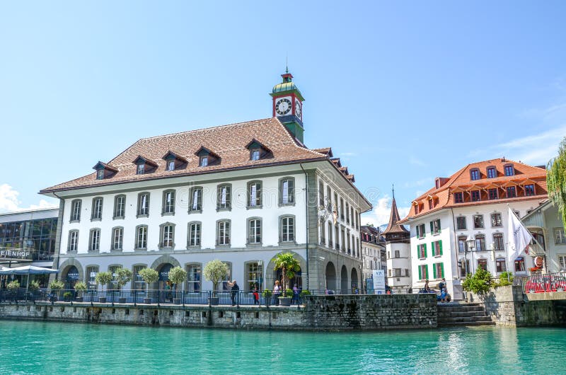Thun, Switzerland - August 8, 2019: Beautiful cityscape of the Swiss city. Medieval houses located along the turquoise Aare river. People walking by the canal stock images
