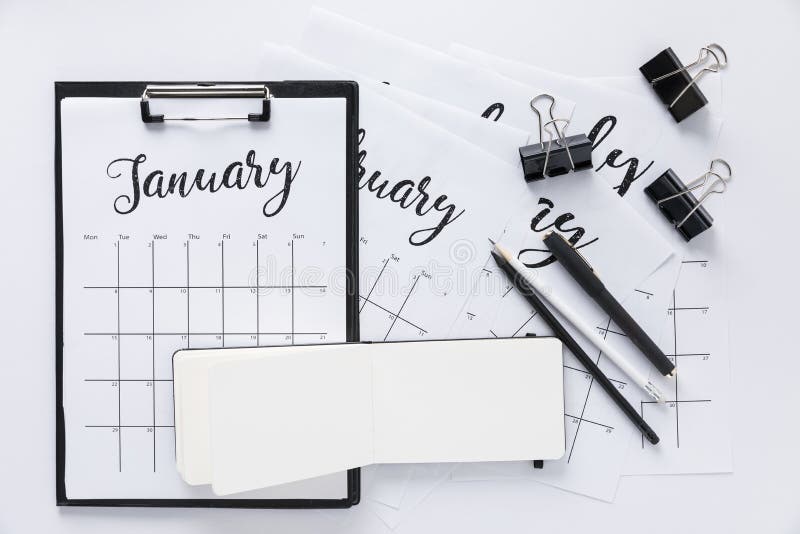 Top view of arrangement of office supplies and calendar. Isolated on white stock photos