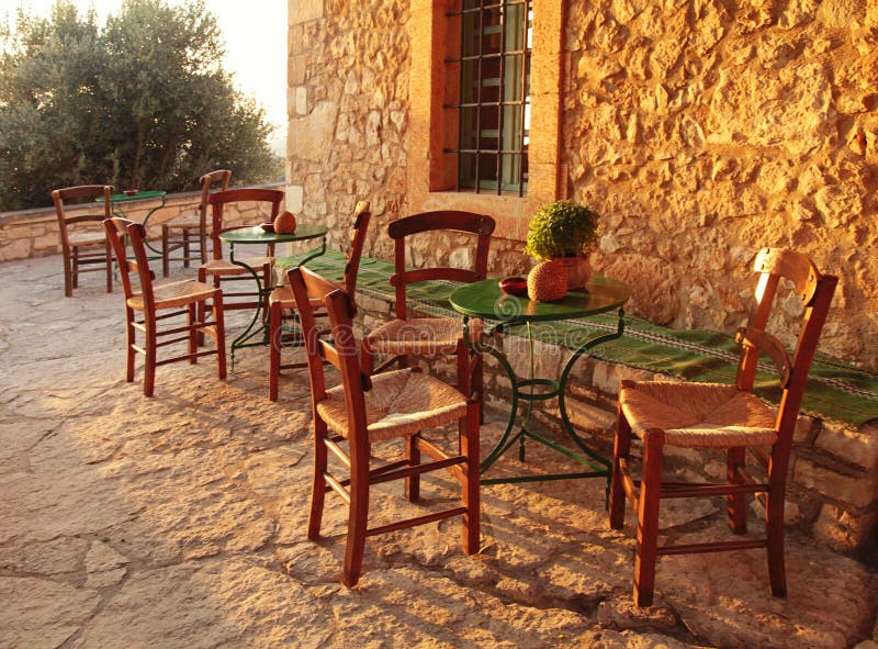 Traditional greek country outdoor restaurant on terrace with empty table, Crete, Greece. Sunset light stock images