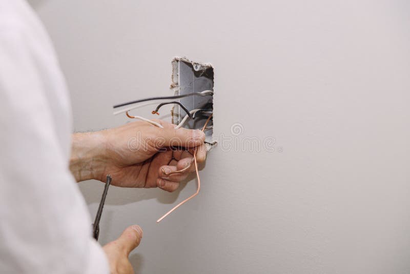 Unfinished electrical mains outlet socket with electrical wires and connector installed in plasterboard drywall royalty free stock images
