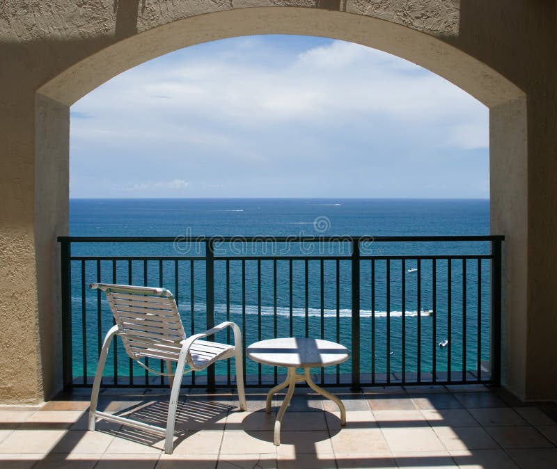 View of Ocean Under Arch. An inviting view of the ocean through an arch of a balcony stock images