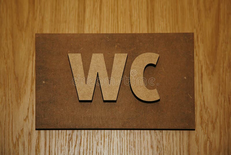 Volumetric plaque on wooden doors toilet rooms - Water Closet - WC. stock image