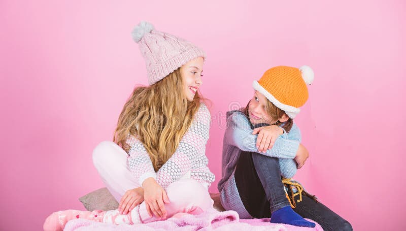 Warm up your winter wear with cute and cozy accessories. Siblings wear winter warm hats sit on pink background. Children royalty free stock images