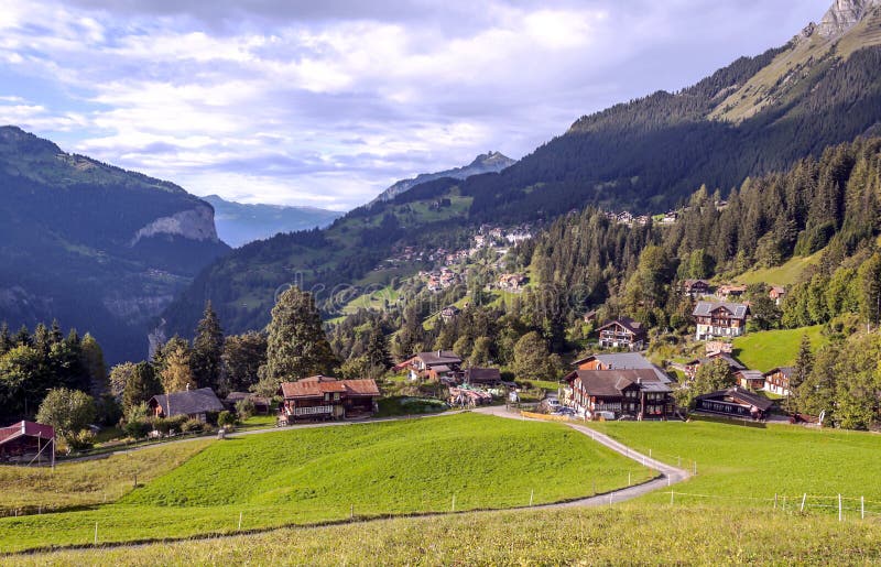 Wengen in the swiss Alps. In a valley with rural houses, in the background are mountains on a cloudy day royalty free stock photography