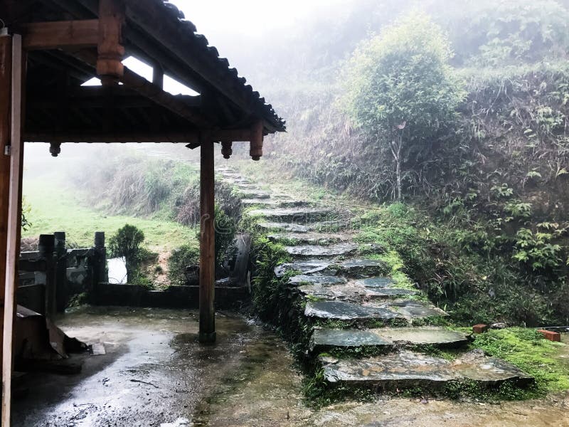 Wet path near country house in Tiantou village. Travel to China - wet path near country house in Tiantou village in area Dazhai Longsheng Rice Terraces (Dragon