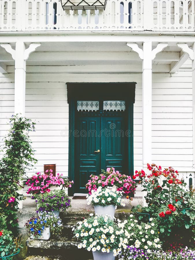 White wooden country house entrance door terrace cozy exterior with flowers. Design decoration and balcony retro style traditional building royalty free stock photos