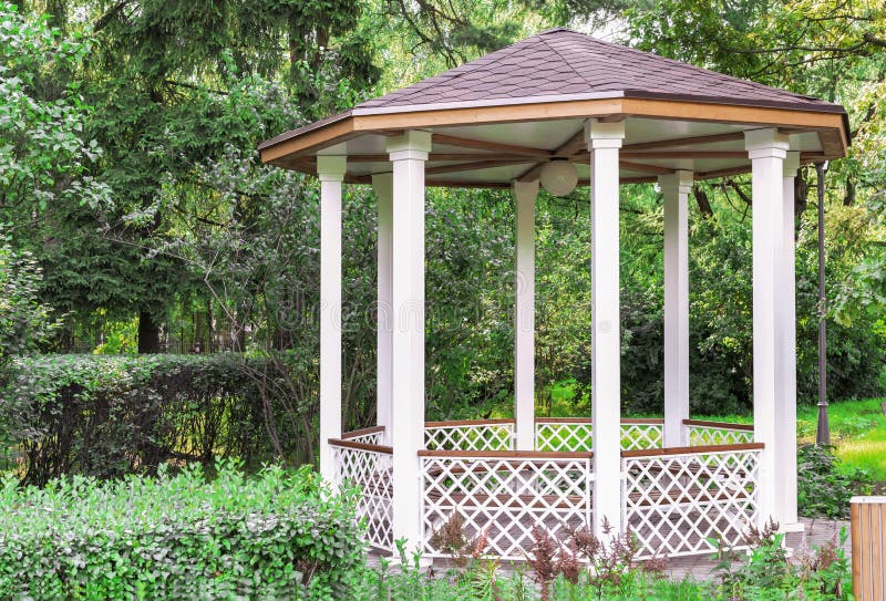 White wooden gazebo in a summer park. Garden pergola royalty free stock photos