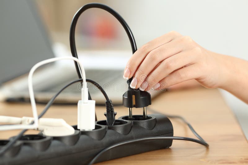 Woman hand plugging a plug in an electrical socket stock photo