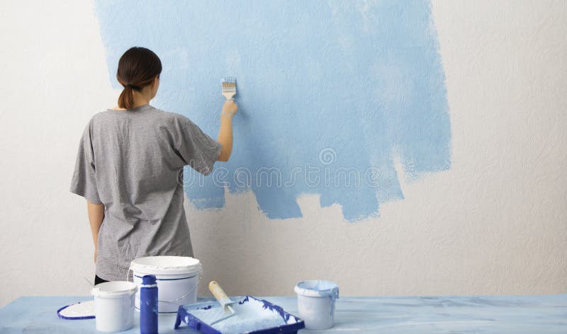 Woman painting interior wall with paint roller in new house stock photos