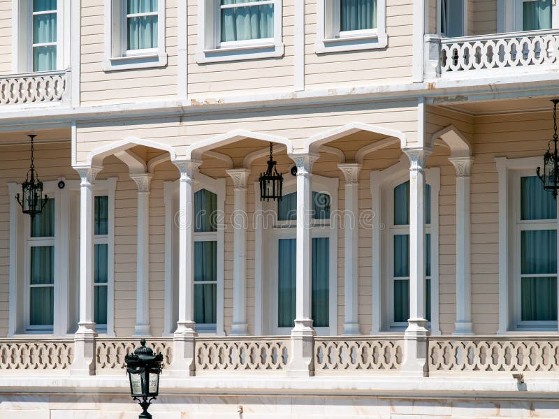 Wooden mansion close up detail. Beautiful classic architecture balcony with arch,  columns and many windows royalty free stock photo