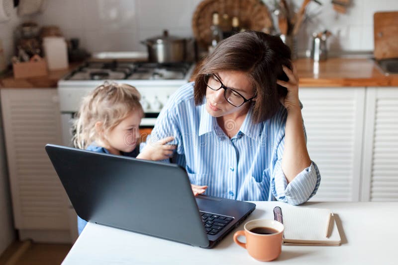 Working mother in home office. Unhappy woman and child using laptop. Sad and angry daughter. Needs attention from busy exhausted mom. Freelancer workplace in royalty free stock photography