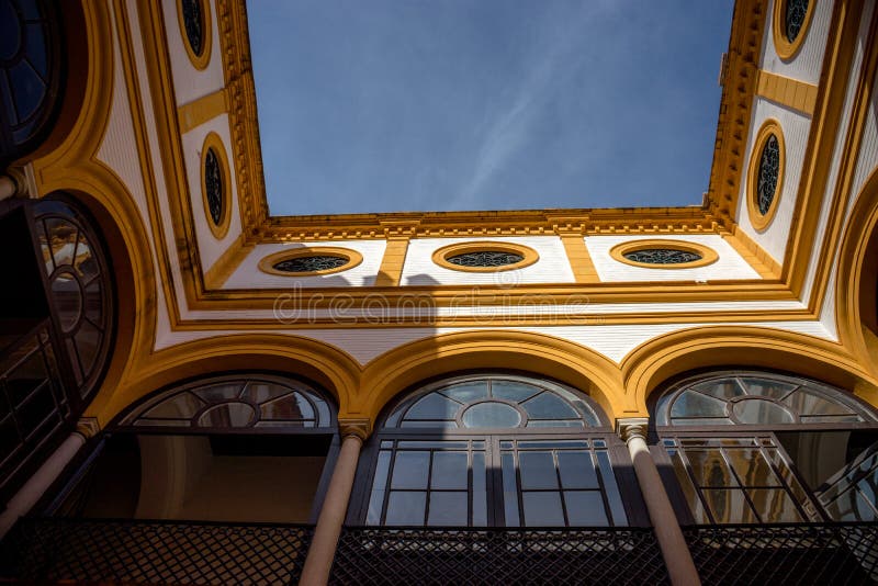 Yellow arch of a balcony against a blue sky in Seville, Spain, E. Urope on a summer day royalty free stock photos