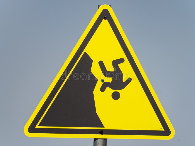 Yellow triangular hazard warning sign on a gray background royalty free stock photo