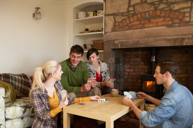 Young couples in cosy cottage. Having fun playing games stock images