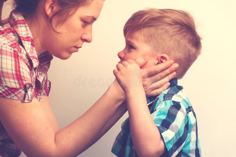 Young mother comforting her little crying child. Young mother comforting little crying boy. Sad unhappy child looking to the mom . Family relations problems royalty free stock photos