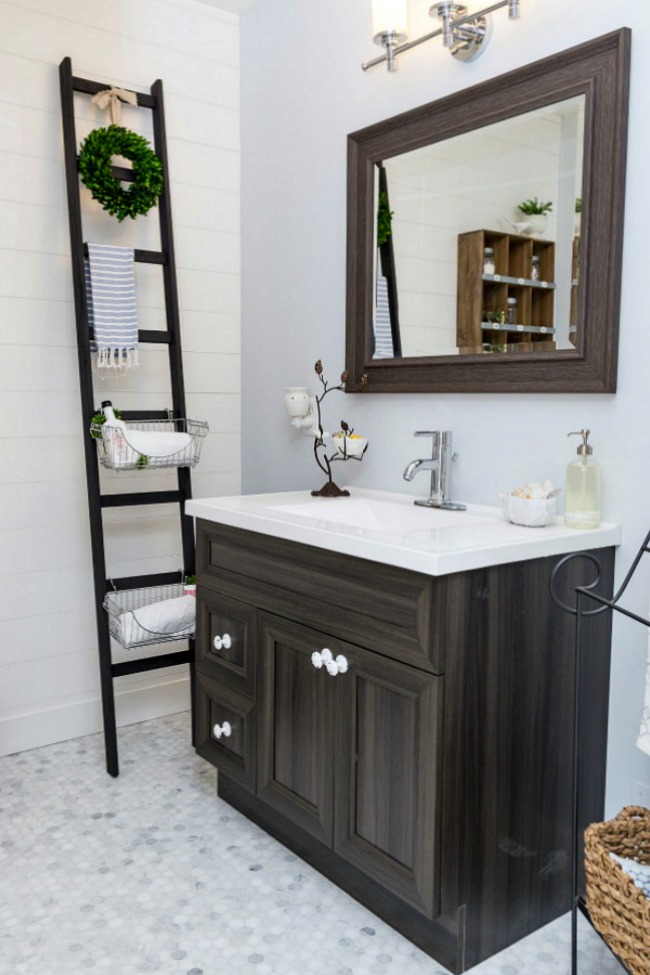 Decluttered and organized bathroom space with neutral colors and dark wood tones.