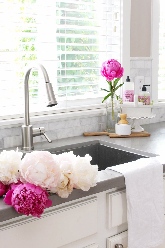 Pink peonies in a white kitchen.