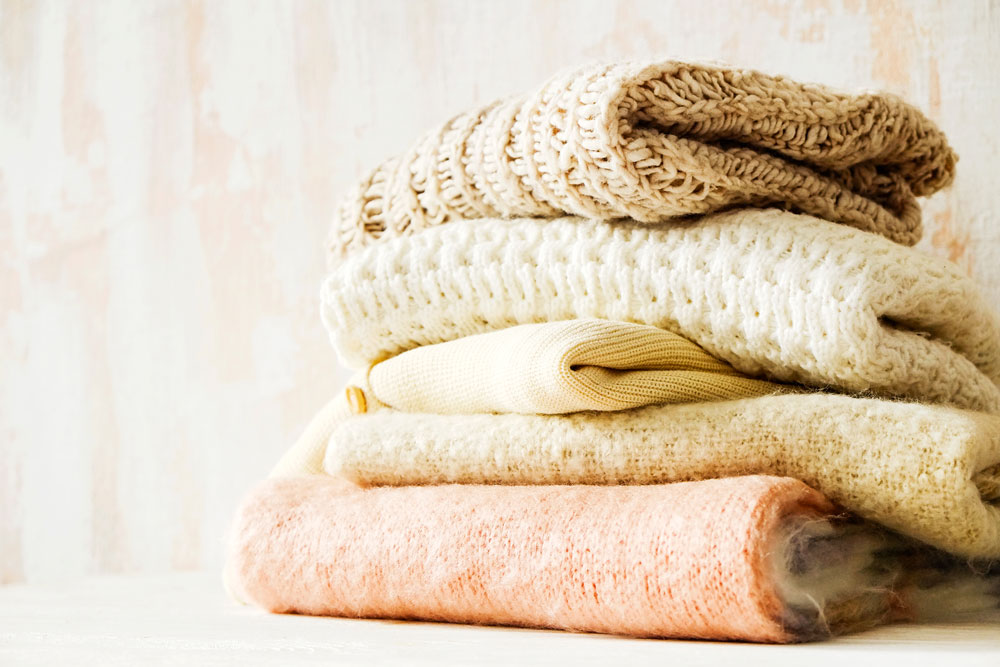 pictures of stacked sweaters on a counter