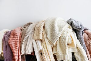 picture of a bunch of sweaters hanging over a couch 
