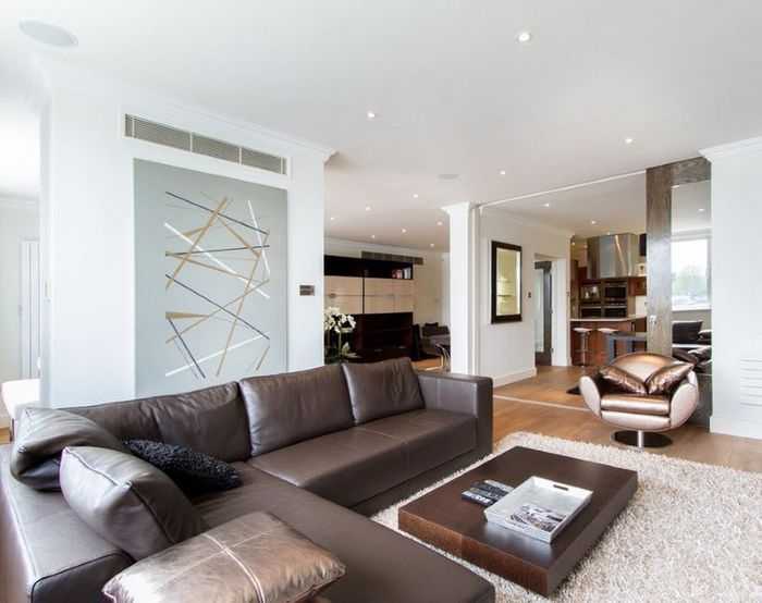Интерьер светлой гостиной в стиле минимализма с коричневым диваном