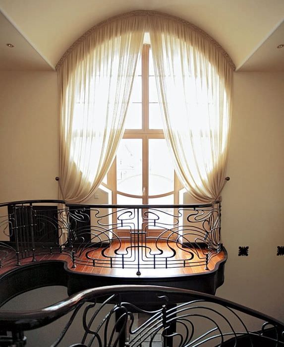 Круглое окно с дверью на балкон частного дома