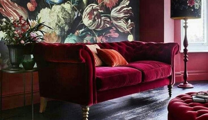 a red velvet tufted sofa against a floral wallpaper - room colors and moods - red psychology - color psychology