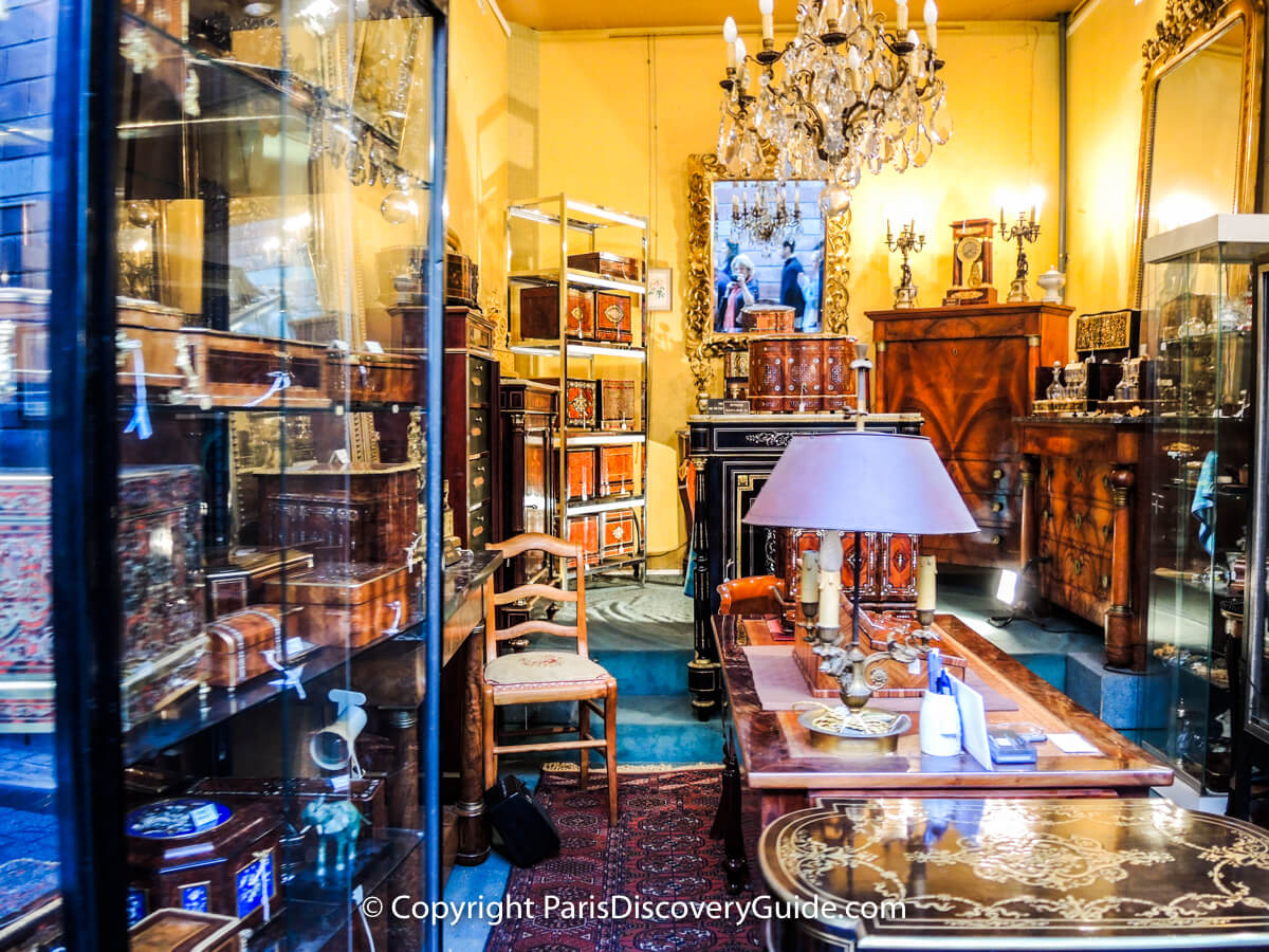 Inlaid boxes and fine furniture in antiques showroom at Paris Flea Market