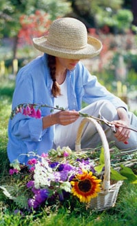 lady with cut flowers in basket in garden
